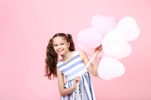 Young girl with balloons on pink background - Valokuva, kuva