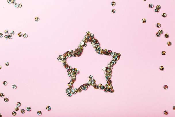 Round colorful sequins in star shape on pink background - Foto, imagen
