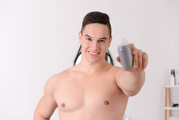 Fiatal férfi dezodor-fürdőszoba - Fotó, kép