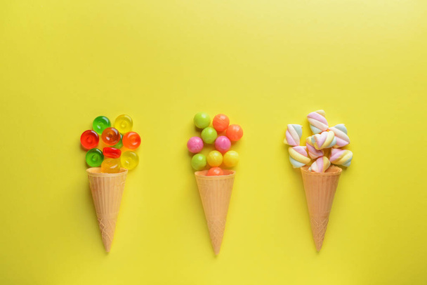 Composition with tasty sweets and waffle cones on color background - Photo, Image