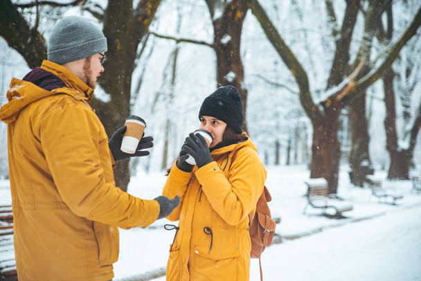 couple walking by snowed city park talking socializing. romantic date in winter time. christmas is coming - Фото, зображення