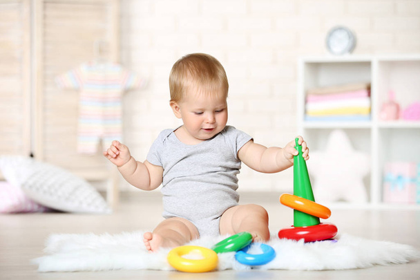 Baby boy with toys sitting on carpet at home - Photo, Image