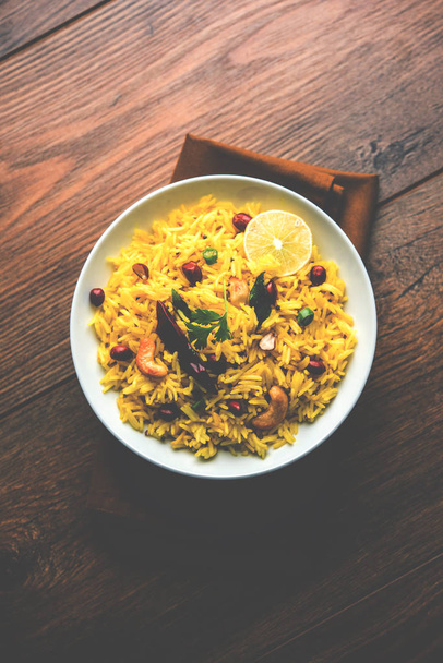 Lemon Rice é um arroz açafrão do sul da Índia ou receita maharashtrian chamado fodnicha bhat usando sobras de arroz decorado com folhas de curry nozes e suco de limão, foco seletivo
 - Foto, Imagem