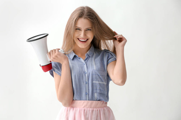 Young woman with megaphone on white background - 写真・画像