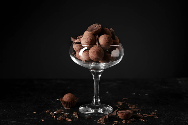 Glass bowl with sweet truffles on dark background - Foto, Imagem
