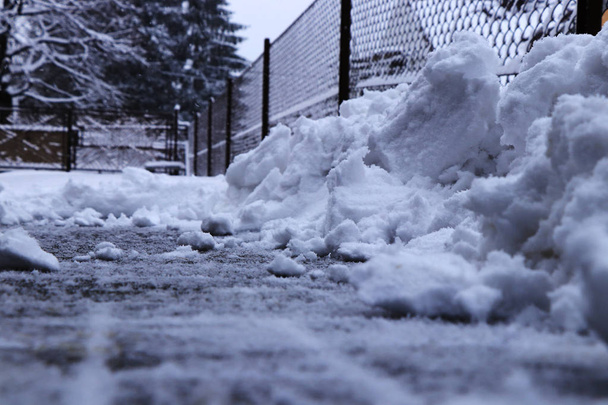 Un mucchio di neve vicino alla recinzione. Cerco di spalare la neve dal vialetto. Venti centimetri di manto nevoso devono essere puliti
. - Foto, immagini