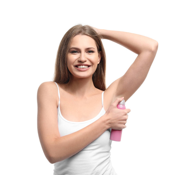 Beautiful young woman with deodorant on white background - Photo, Image