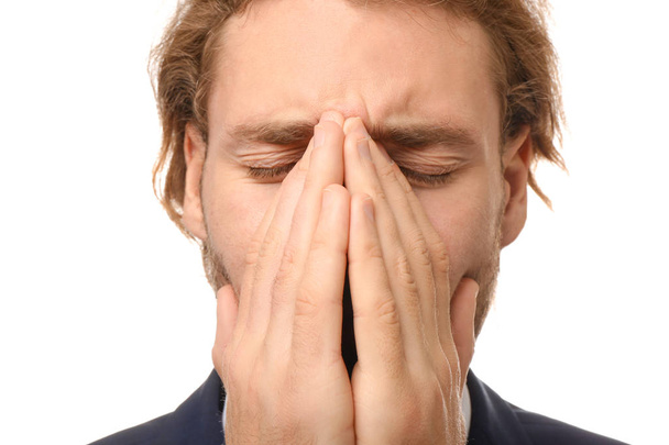 Young businessman suffering from headache on white background, closeup - Zdjęcie, obraz