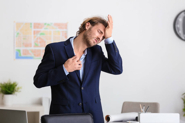 Giovane uomo d'affari che soffre di mal di testa in ufficio
 - Foto, immagini