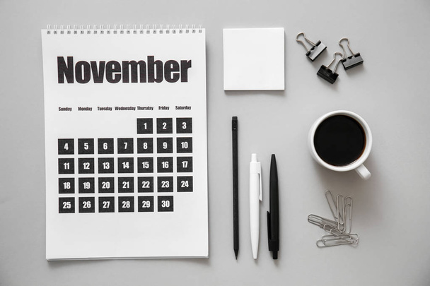 Página del calendario de noviembre con papelería sobre fondo gris
 - Foto, Imagen