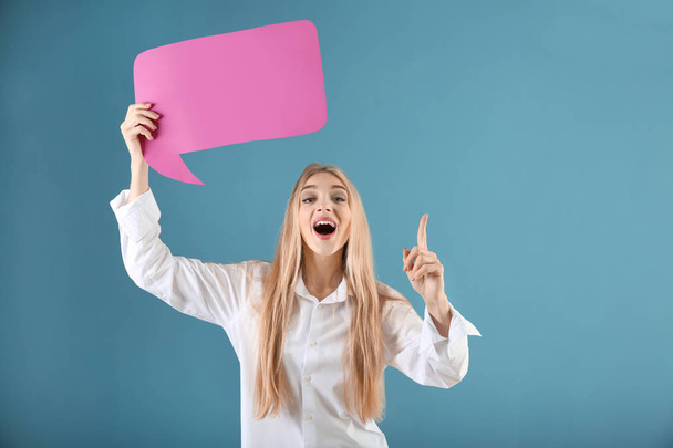Young woman with blank speech bubble and raised index finger on color background - Photo, image
