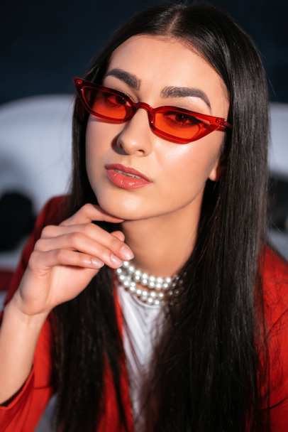 portrait of beautiful brunette girl in red sunglasses looking at camera  - Photo, Image