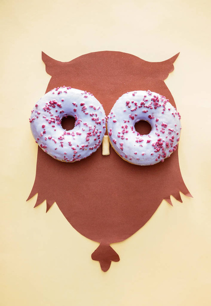 Paperipöllö maukkaita donitseja kevyellä taustalla
 - Valokuva, kuva