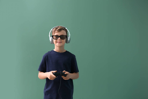 Cute boy playing video game on color background - Photo, Image