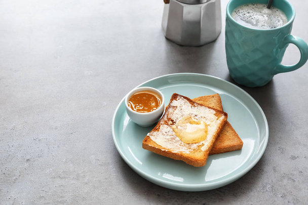 Plate with tasty toasts and honey on table - Fotoğraf, Görsel