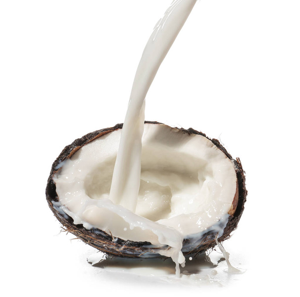Połowa świeżego kokosa z splash mleko na białym tle - Zdjęcie, obraz