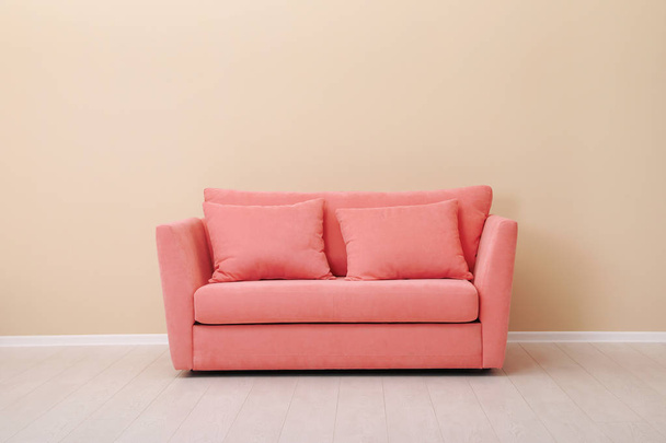 Stylish sofa near wall. Interior design with living coral color  - 写真・画像