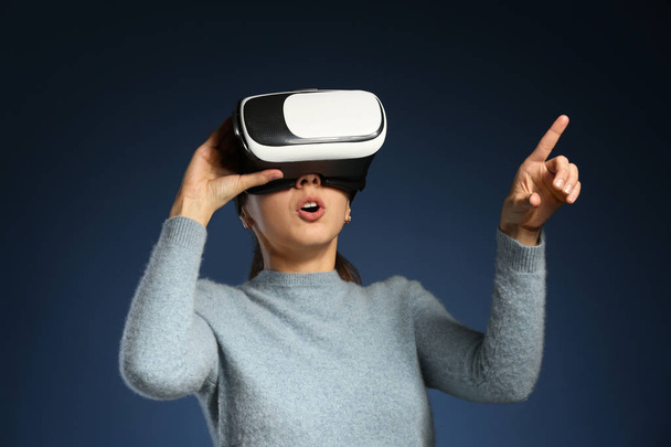 Jovem com óculos de realidade virtual em fundo de cor - Foto, Imagem