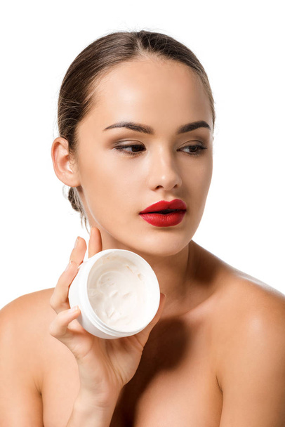 attractive girl with red lips holding jar with face cream isolated on white - Фото, изображение