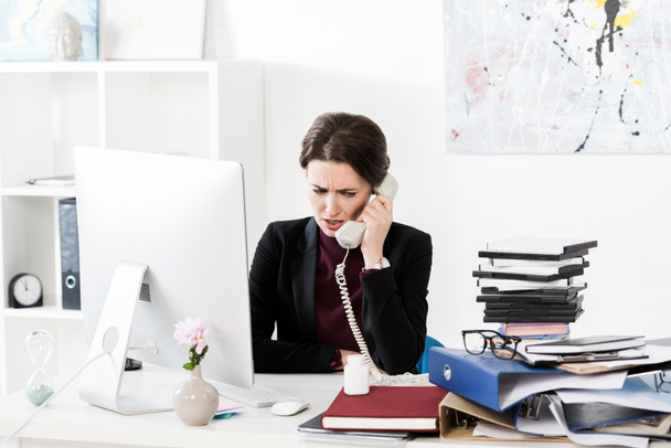Wütende attraktive Geschäftsfrau telefoniert im Büro - Foto, Bild