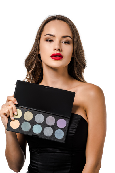 attractive girl holding palette with eyeshadows and looking at camera isolated on white - Foto, immagini
