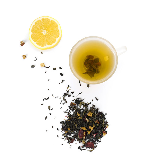 Cup of hot tea, dry leaves and lemon on white background - Foto, Imagem