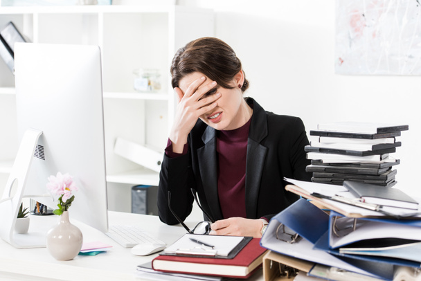 сумна виснажена бізнес-леді торкається лоба за столом в офісі
 - Фото, зображення