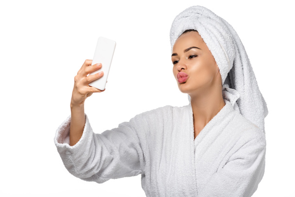 beautiful girl in bathrobe taking selfie isolated on white - Photo, Image