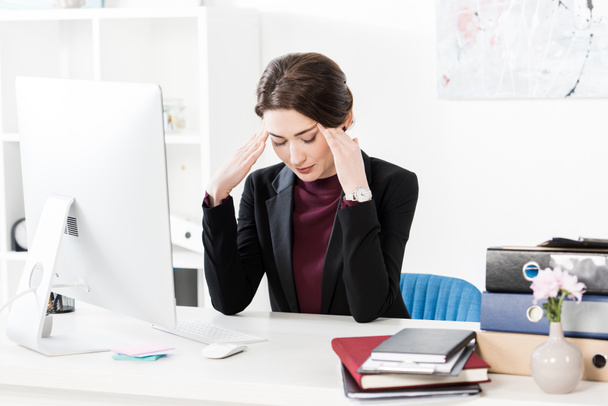 traurig erschöpfte Geschäftsfrau mit Kopfschmerzen und Berührung des Kopfes im Büro - Foto, Bild