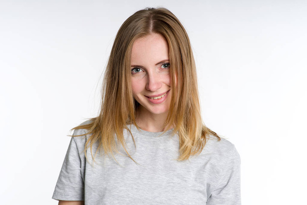 Portrait of a smiling woman in a shirt on a light background. - Foto, Imagen