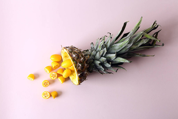 Ripe cut pineapple and cumquat on color background - 写真・画像