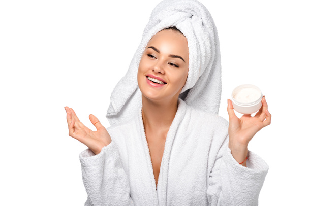 attractive girl in bathrobe holding jar with cream and smiling isolated on white - Valokuva, kuva