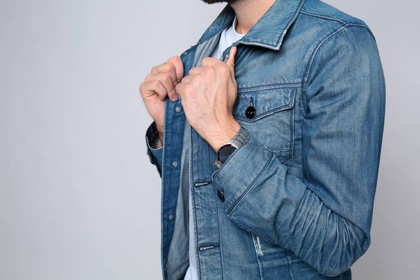 Young man in stylish jeans jacket on light background, closeup - Foto, Imagem