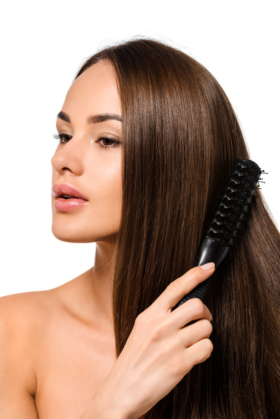beautiful girl combing long hair with hairbrush isolated on white - Zdjęcie, obraz