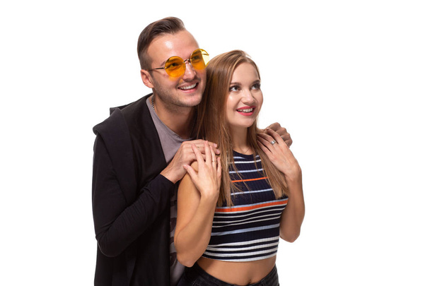 Happy young lovely couple standing together and laughing. Studio shot over white background. - Foto, Bild