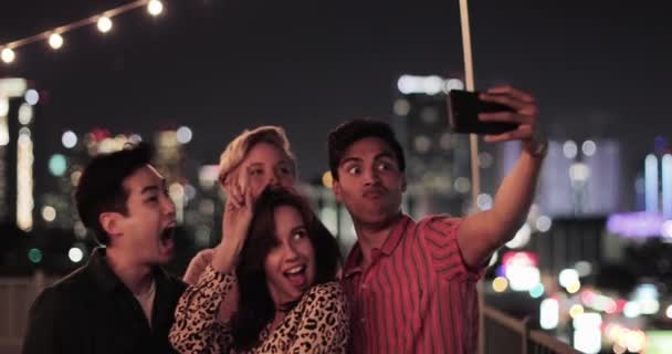 Ομάδα φίλων για τη λήψη selfie με ορίζοντα της πόλης τη νύχτα - Πλάνα, βίντεο