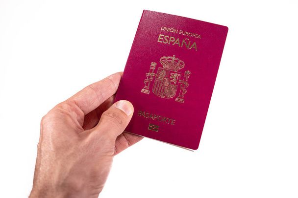 Hombre caucásico mano izquierda ofreciendo pasaporte español
 - Foto, imagen