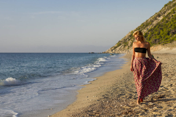 όμορφο κορίτσι με φούστα περπάτημα στην παραλία παραλία - Φωτογραφία, εικόνα