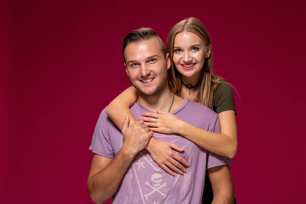 Jovem casal bonito posando no estúdio, expressar emoções e gestos, sorrindo, em um fundo de Borgonha
 - Foto, Imagem