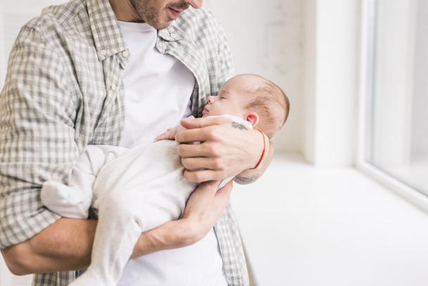 cropped shot of father holding little sleeping son in hands - 写真・画像