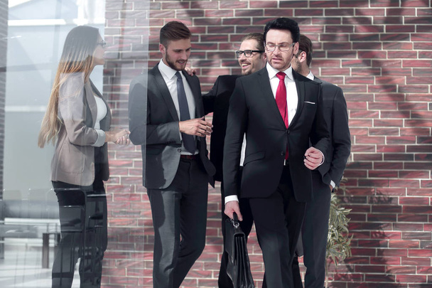 бизнесмен и его команда идут по офисному коридору
 - Фото, изображение