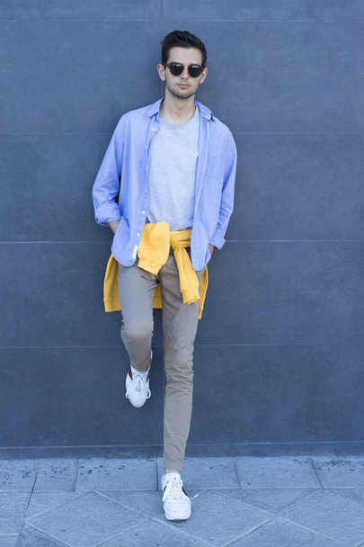 модный молодой человек на стене улицы
 - Фото, изображение