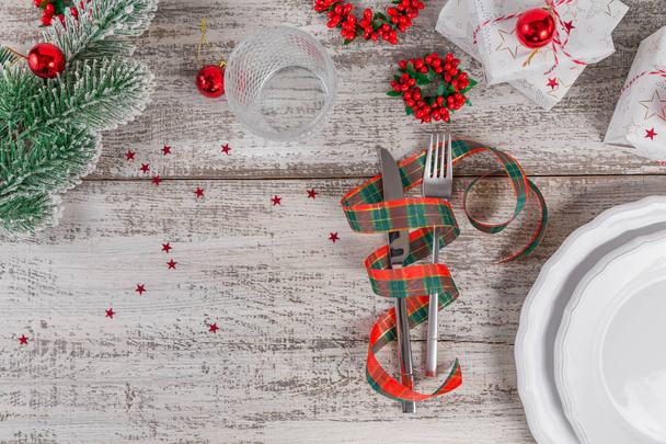 Winter place setting with Christmas and New Year decorations on white wooden table. Festive table setting for Christmas dinner. Top view with copy space for text - Fotoğraf, Görsel