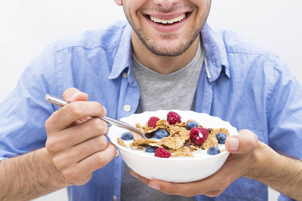 young man eating cereal with fruit - Foto, Bild