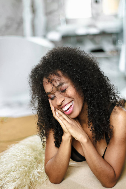 Young afro american girl lying in underwear and smiling. - Photo, image