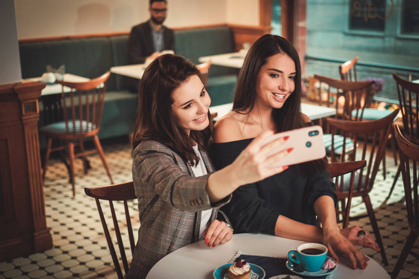 Beaufitul smiling girlfriends taking selfie - Foto, Imagen