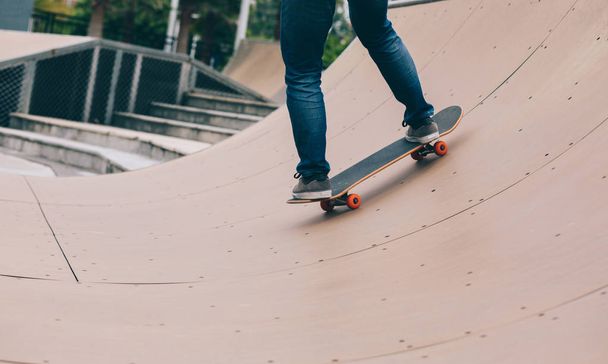 Young woman skating on ramp at skatepark - Фото, изображение