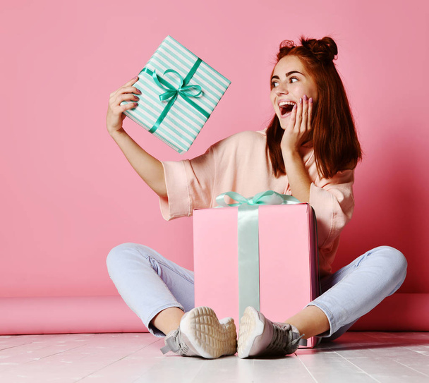 glückliche junge Frau mit Geschenken vor rosa Hintergrund. - Foto, Bild