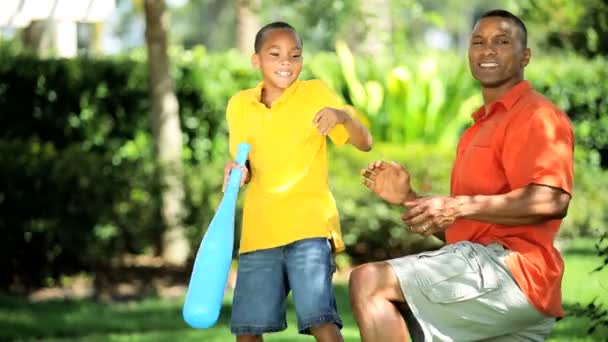 Padre étnico e hijo practicando balanceo de béisbol
 - Metraje, vídeo