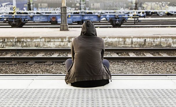 Nő ül a vasútállomáson, részlet várja, hogy megragad egy vonat - Fotó, kép